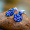 handmade earrings made of purple clay with a unique imprint.