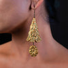 side profile of a woman wearing handmade earrings made of clay, glass beads, hemadite.