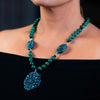 Woman wearing a fashion statement necklace made of clay malachite and spinal.