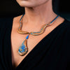Woman wearing a fashion statement necklace made of clay, chrysocolla, and lapis