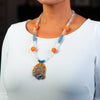 Woman wearing a fashion statement necklace made of clay, spectrolite quartz, dumortierite, fossilized sponge coral and kyanite.