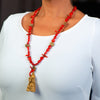 Woman wearing a fashion statement necklace made of clay,  coral, druzy and hematite.