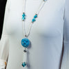 Long fashion statement necklace made of clay, moonstone, and shell pearls.