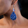 side profile of a woman wearing handmade earrings made of clay, amethyst and sterling silver balls. 