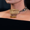 Woman wearing a golden fashion statement necklace made of clay, Czech glass and freshwater pearls.