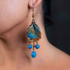 side profile of a woman wearing handmade earrings made of clay, fresh water pearls and lapis.