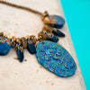 fashion statement necklace made of clay, lapis, druzy,  and pewter balls with a 3 inch pendant.