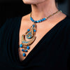 woman wearing handmade necklace made of clay, lapis, and fresh water pearls.