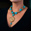 Woman wearing a fashion statement necklace made of clay, turquoise and fresh water pearls.