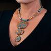 Woman wearing a fashion statement necklace made of clay sea sediment jasper, picture jasper, druzy and chrysocolla.