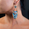 side profile of a woman wearing handmade earrings made of clay, Czech glass, and fresh water pearls.