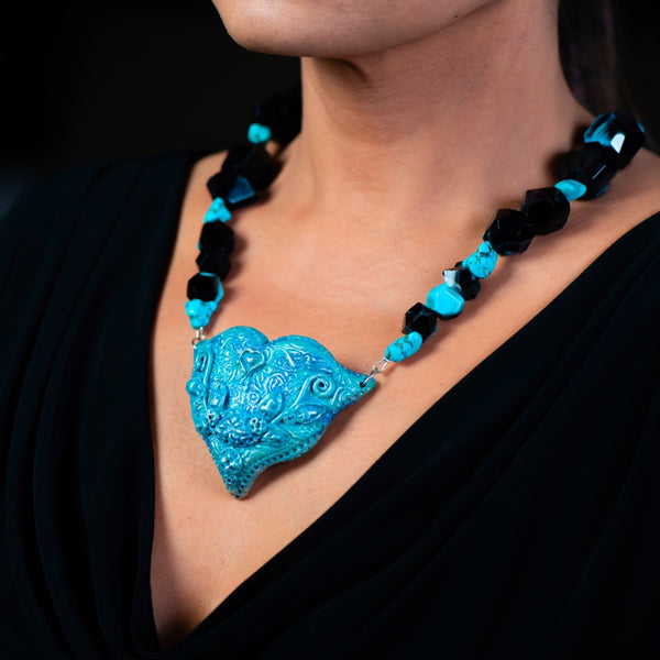 Fashion statement necklace made of clay, turquoise and dragons vein agate with a heart shaped blue pendant.